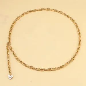 Detailed view of golden heart-shaped shell pendant with pearl on beach style waist chain