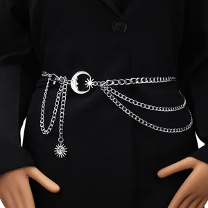 Detail of silver triple-layer metal waist chain with moon and star charms on black fabric