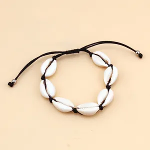 Close-up of handmade shell necklace with adjustable black wax cord and seven cowries