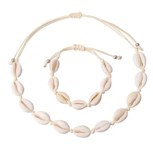 Flat lay of white natural seashell necklace and bracelet set with braided rope