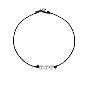 Collana minimalista in corda intrecciata nera con tre perle bianche su sfondo bianco