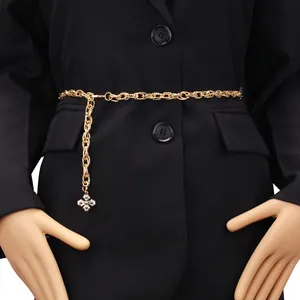 Golden double-layered chain belt with cross pendant and crystals over black blazer