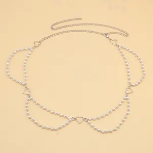 Detail einer mehrlagigen silbernen Taillenkette mit Kunstperlen und Herzanhängern