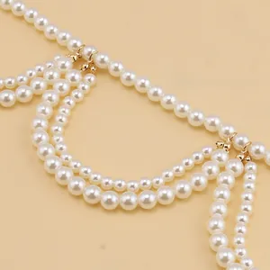Macro detail of elegant multi-layer white pearls and golden link accents for dress