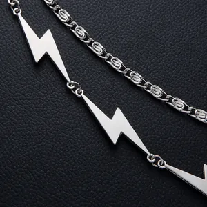 Silver punk lightning pendant with spiral chain over black leather background