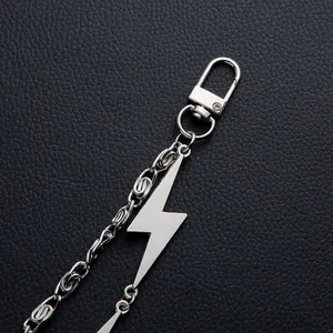 Macro shot of punk style silver lightning pendant and heavy metal chain on leather