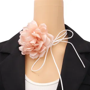 Macro view of peach fabric 3D flower choker necklace on a mannequin with black blazer