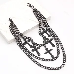 Detail showing vintage cross pendants on a multi-layer punk matte black waist chain