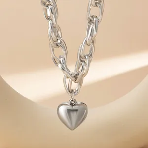 Dettaglio ravvicinato di una collana a catena con ciondolo a cuore in argento lucido