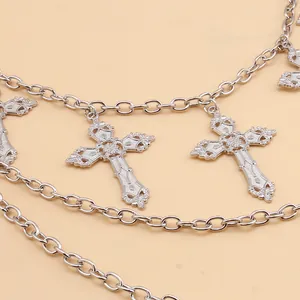 Detail of silver multi-layer chain featuring vintage engraved cross pendants