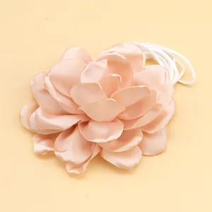 Detail of a dusty pink fabric flower neck strap with soft multi-layered petals and elastic cord