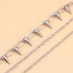 Detail einer mehrlagigen silbernen Metallkette im Punk-Stil mit kegelförmigen Nieten