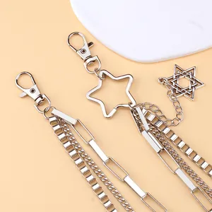 Detail of silver star chain belt featuring lobster clasp and hollow star buckle on pink background