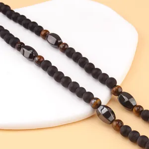 Detalle de piedras ojo de tigre y cuentas de ónix negro mate en una cadena decorativa