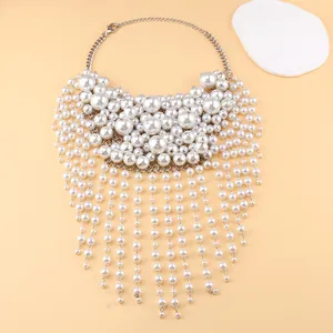 Détail macro du collier de perles multicouche avec pompon et chaîne en métal argenté