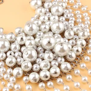 Détail de perles artificielles multicouches avec montures en métal argenté et glands
