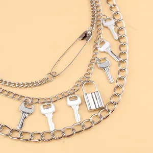 Detalle de cadena de cintura punk multicapa de metal plateado con dijes de llave