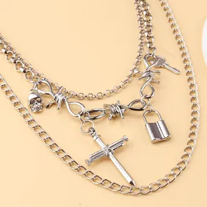 Detail of punk silver multilayer body chain with skull, cross, and padlock charms