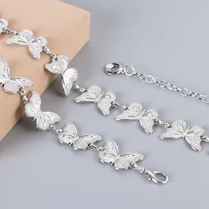 Detail of silver butterfly pant chain with textured metal butterfly charms and lobster clasp