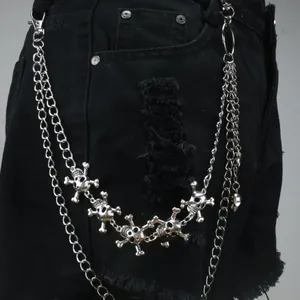 Punk style multi-layer silver metal trouser chain with skull charms on denim jeans