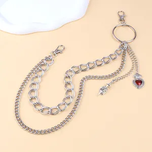 Punk silver multi-layer trouser chain with red heart and dagger charms on cream backdrop