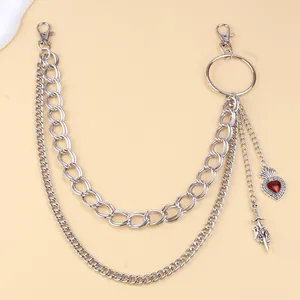 Detail of silver layered pant chain with red heart pendant and sword charm in punk style