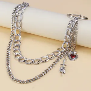 Detail of multi-layered silver pant chain with red heart and silver sword pendants