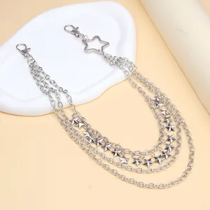 Detail of silver multi-layer metal waist chain featuring star pendants and lobster clasps