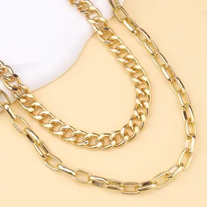 Close-up of double-layer golden necklaces with cuban and paperclip chain details