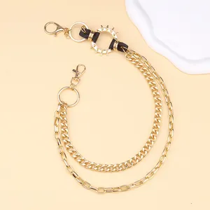 Close-up of golden punk waist chain with layered Cuban links and spiked leather ring