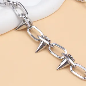 Macro shot of silver punk metal chain with conical rivet spikes and polished links