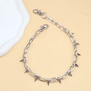 Detail of punk silver metal chain with sharp cone studs and lobster clasps for pants