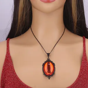 Macro shot of Gothic necklace featuring an orange gemstone and black hollow lace frame