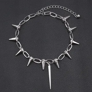 Detalle de collar punk plateado con remaches de punta sobre fondo de cuero negro rugoso