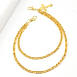 Close-up of golden double-layer punk pants chain with a hollow cross pendant and clasps