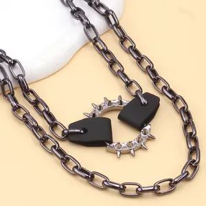 Detail view of punk style black box chain with metallic spiked ring and leather accents