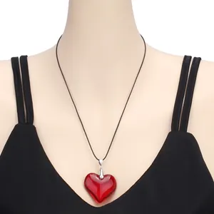 Close-up of red glass heart pendant necklace with black cord and silver buckle