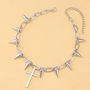 Detalle de collar punk plateado con púas metálicas afiladas y un colgante en forma de cruz