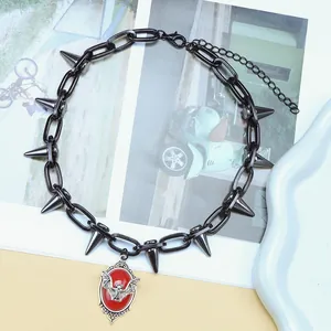 Detalle del collar punk con remaches negros y colgante de murciélago rojo vibrante