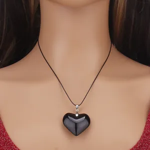 Minimalist black glass heart pendant necklace on red sequin dress mannequin display