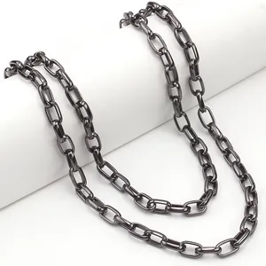 Close-up of gunmetal grey box chain with oval links on a white minimalist display stand