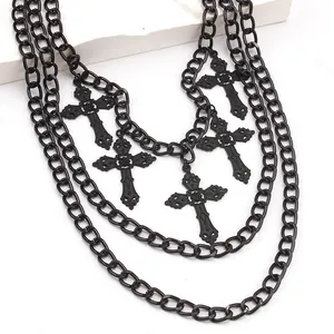 Macro detail of multi-layered gothic black chain necklace with carved cross pendants