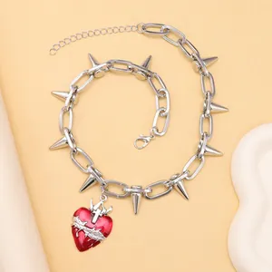 Vista macro del collar punk con púas y colgante de corazón rojo con espinas