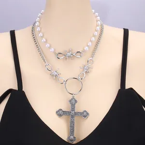 Detalle de collar punk de doble capa con perlas, cadenas y colgante de cruz grande