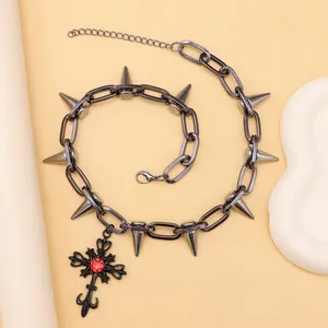 Collar punk detallado con púas metálicas y gran cruz gótica con una piedra preciosa roja