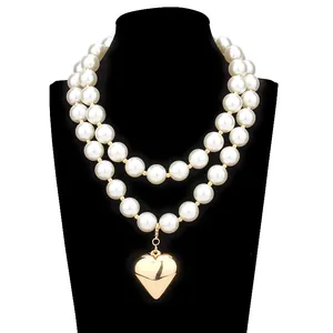 Elegant double-layer pearl necklace featuring a large polished gold heart pendant for women