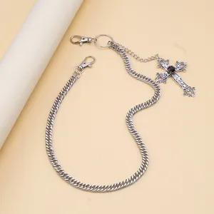 Silver hip hop pants chain with cross pendant and black stone detail macro view