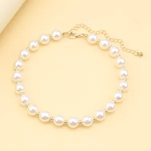 Detail of white pearl necklace with gold metal spacer beads and lobster clasp closure