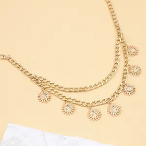 Golden double-layer sun pendant waist chain with metallic finish on beige background