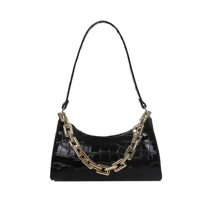 Chic black croc-embossed baguette bag with glossy finish and bold gold chain strap